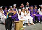 Students at their graduation in purple and white gowns.
